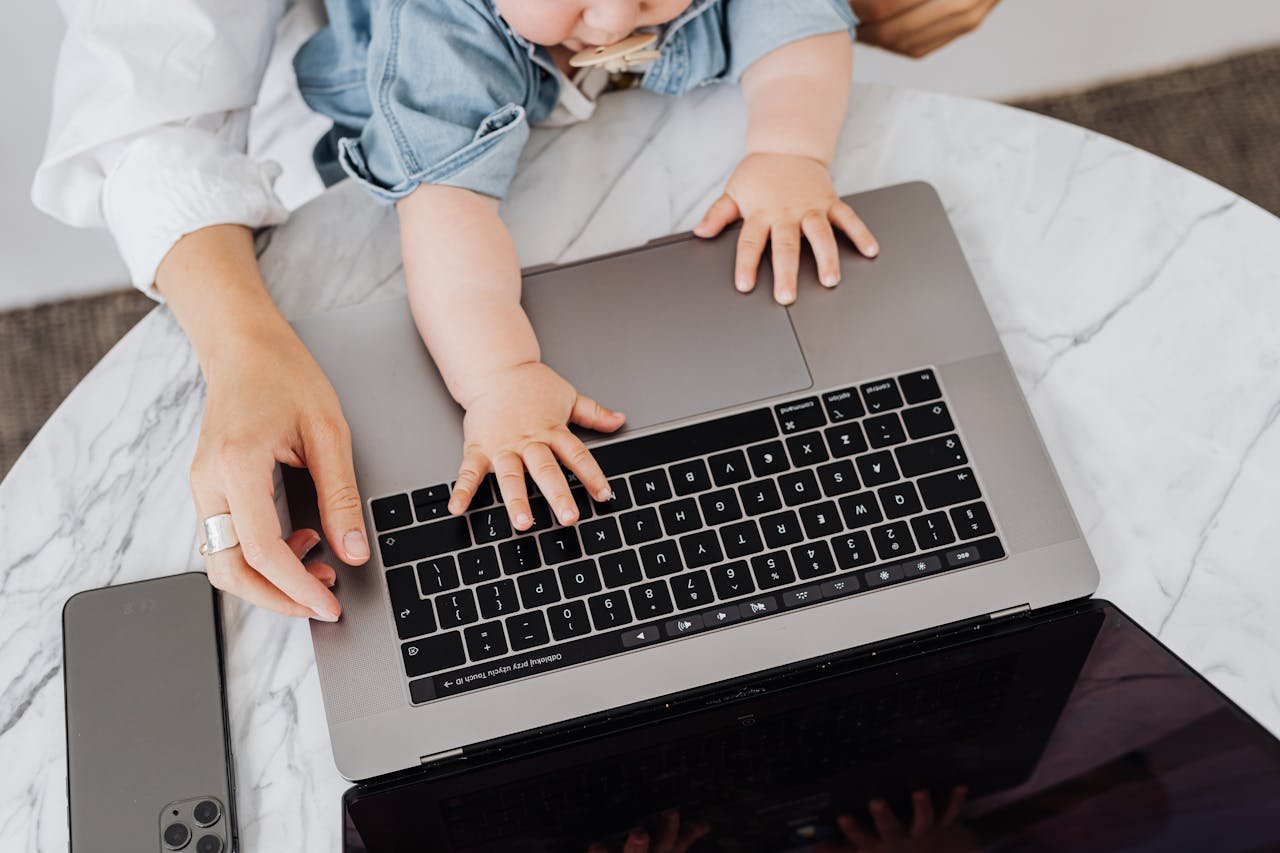 Top view of a parent and a childs hands on a laptop keyboard, symbolizing digital learning.